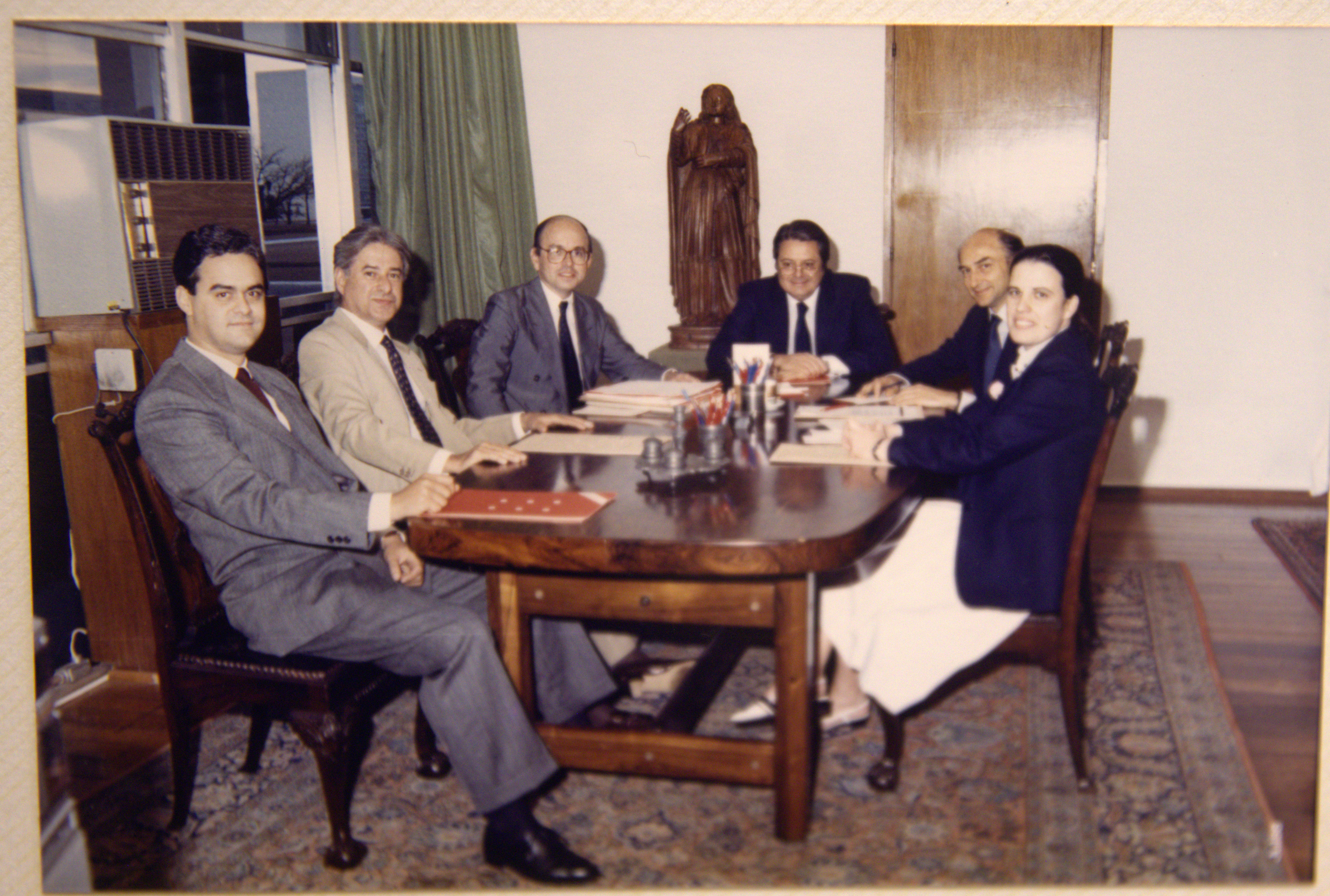 O diplomata Gelson Fonseca Júnior (sentado à direita, ao fundo) posa para foto com colegas e o secretário-geral do Itamaraty, Paulo Tarso Flecha de Lima (que está à esquerda de Gelson, na ponta da mesa). Gelson, à época, trabalhava no gabinete da Secretaria-Geral do Itamaraty.